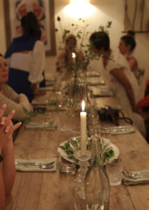 Group of women gathered around a table, sharing food and conversation - illustrating co-regularion and social connection for nervous system balance.